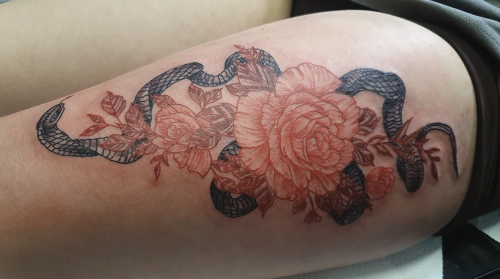 Schlangentattoo mit roten Blumen